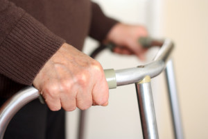 senior hands holding rails of a walker