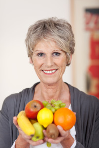 Smiling caregiver holding a variety of fruit