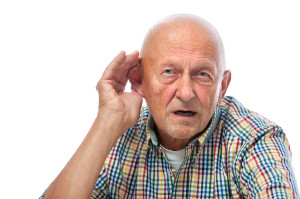 Senior man cupping his ear having difficulty hearing