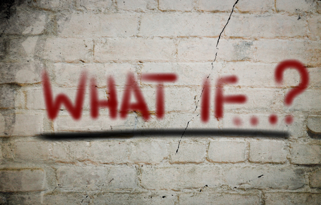 Red "what if?" words painted on gray brick wall