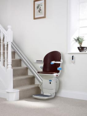 Photo of a stairlift in place at the bottom of the stairs.