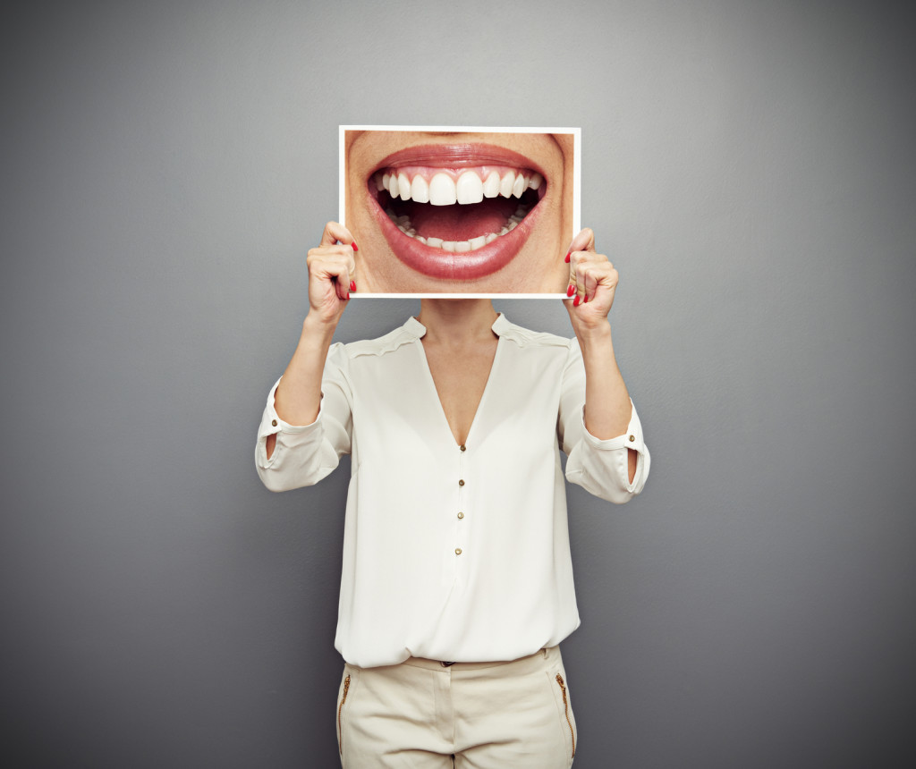 woman holding picture with big smile. concept photo over dark background