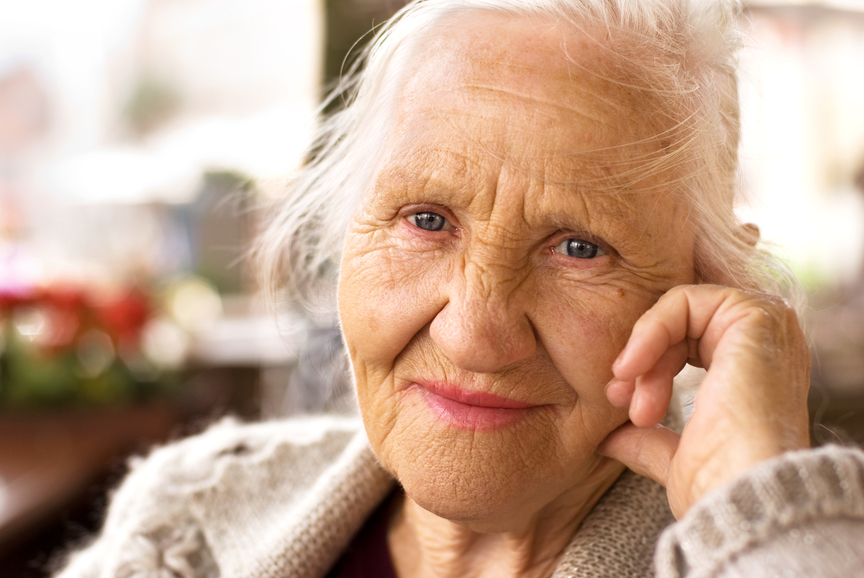 Portrait of the smiling elderly woman, sitting outside