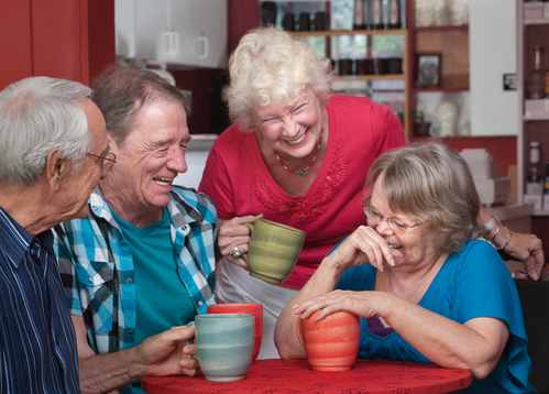 Group of laughing seniors in a coffeehouse