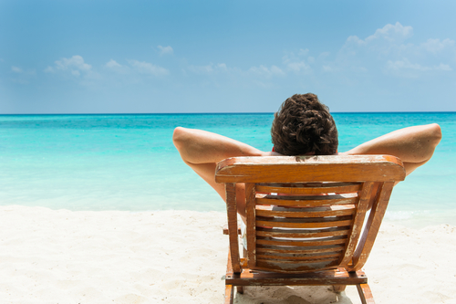 person resting in a beach chair by the shore