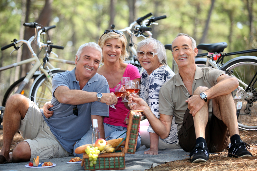 4 midlife people enjoying a picnic in the country