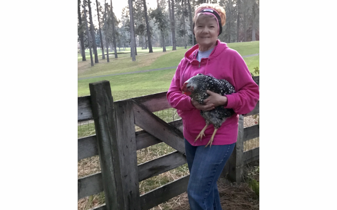 Shelley holding a chicken and wearing CozyPhones