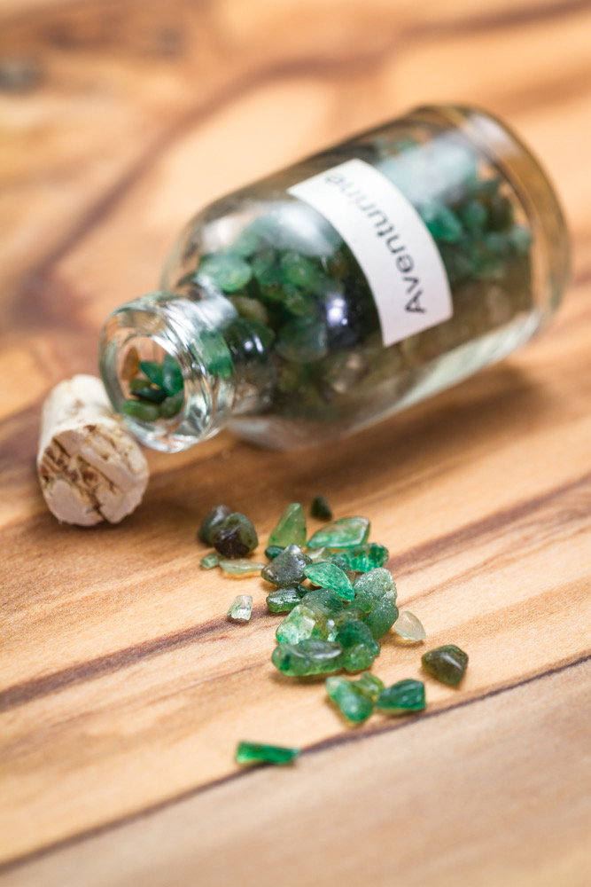 Green adventurine spilling out of a bottle