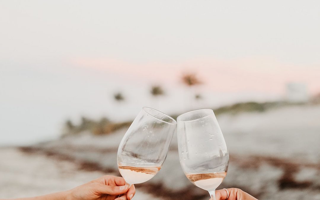 toasting a glass of rose on the beach