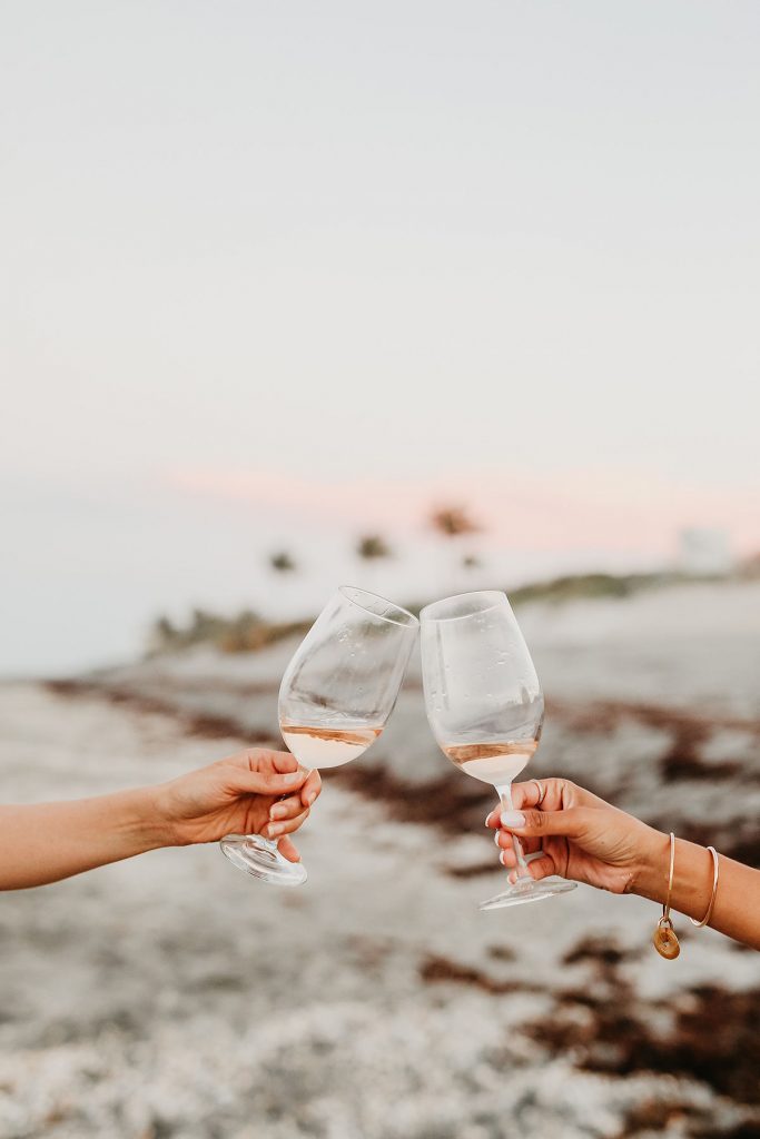 toasting a glass of rose on the beach