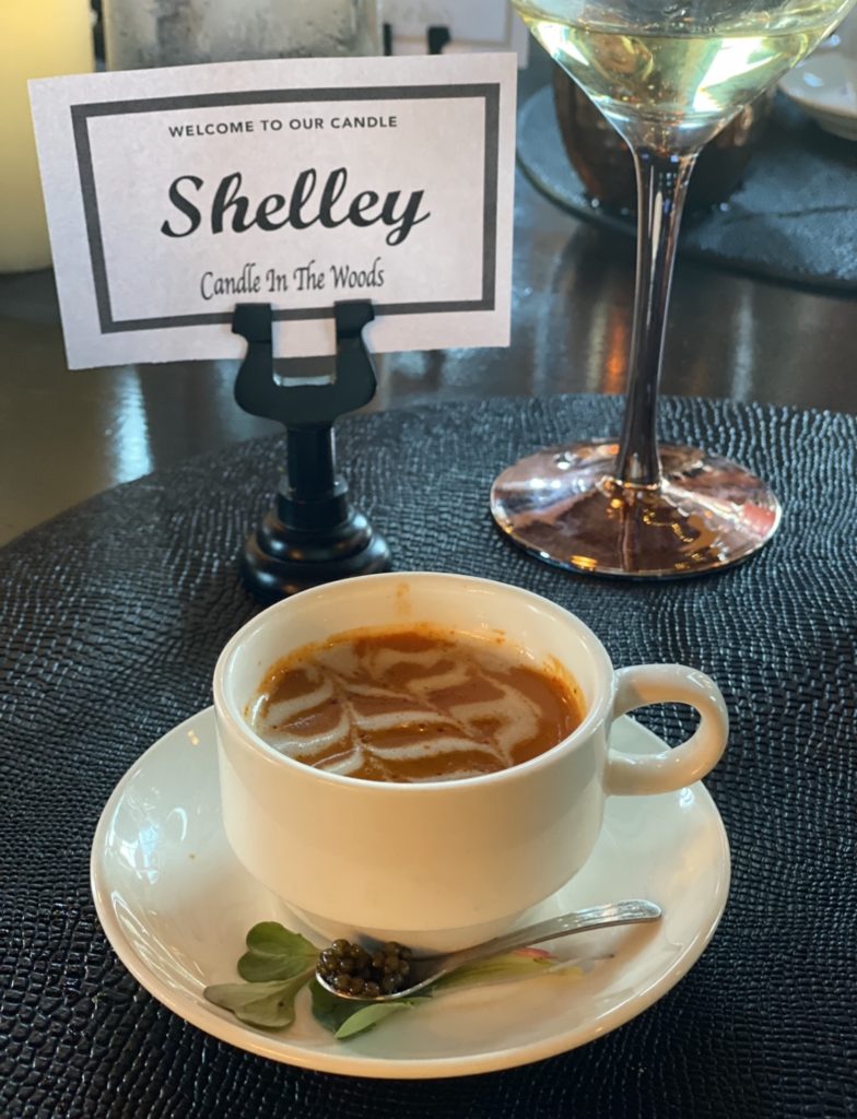 lobster bisque in an Intalian style coffee cup with microgreens and a tiny spoon with caviar in it