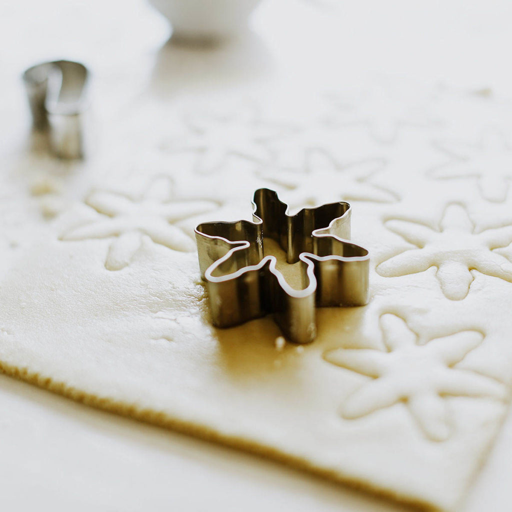 snowflake cookie cutter sitting on rolled out dough