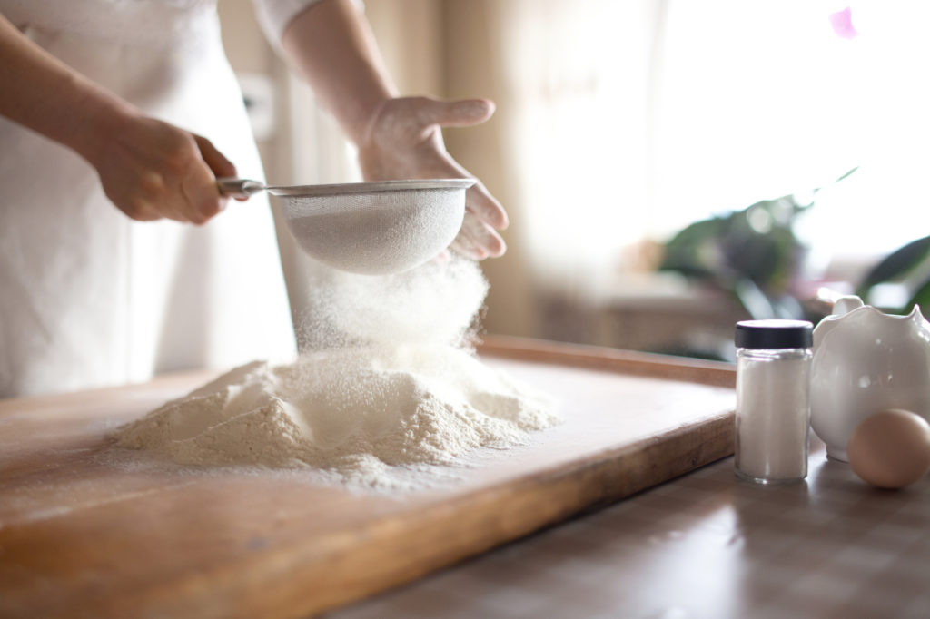 Sifting the flour onto a baking board