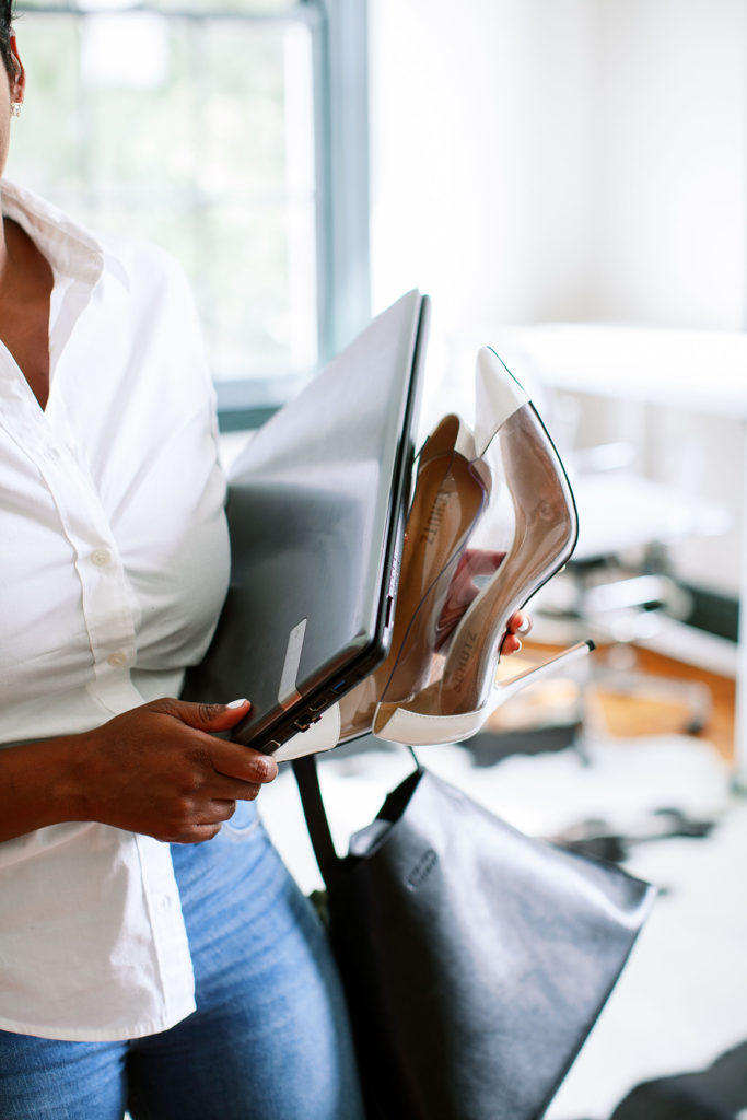 a woman standing beside her desk carrying supplies