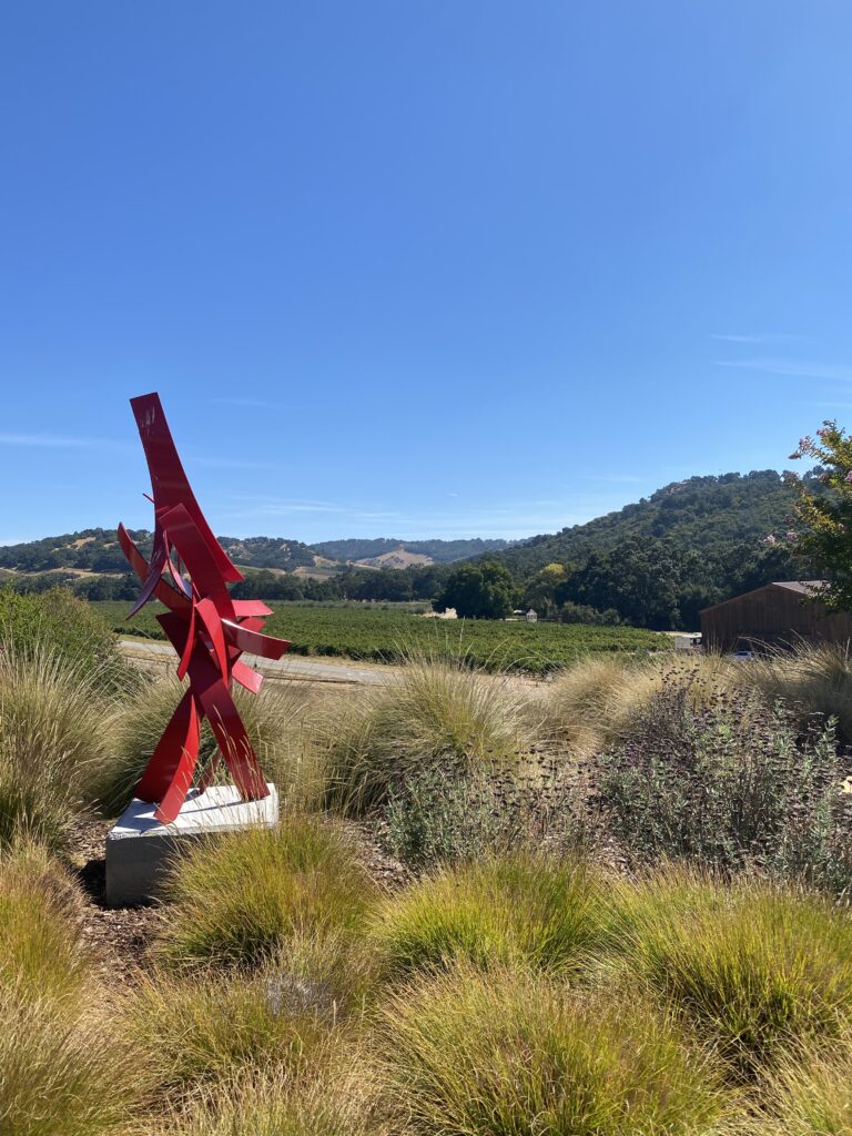 A red aluminum art piece, 'Once Again' by the talented self-taught sculptor Matt Devine.