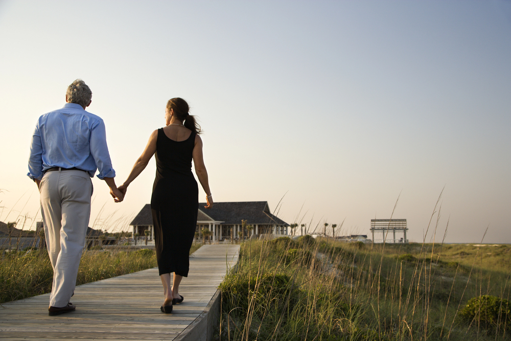 a midlife couple with excellent emotional intelligence walking down a sidewalk.